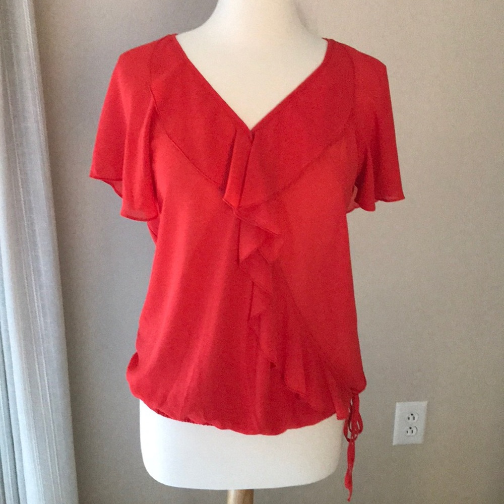 Harlow Zee orange top.